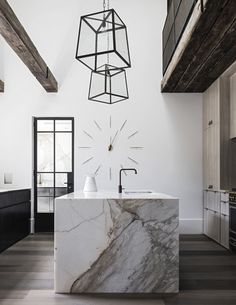 a kitchen with marble counter tops and white walls