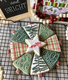 decorated christmas cookies on a cooling rack next to a chalk board and other holiday decorations