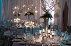 the tables are set with white and blue linens, silverware, and centerpieces