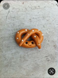 a pretzel with white dots on it laying on the ground