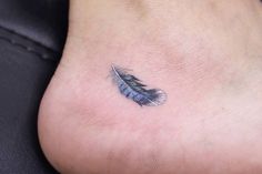 a small feather tattoo on the ankle is seen in this image, it appears to be blue