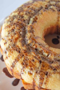 a close up of a donut on a plate with chocolate sauce and sprinkles