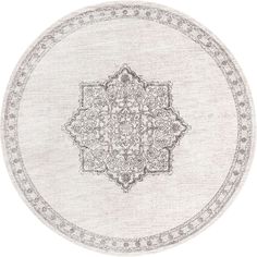 a round rug with an intricate design on the center and sides, in grey tones