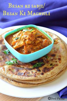 a plate topped with three flat breads covered in curry and chicken sauce on top