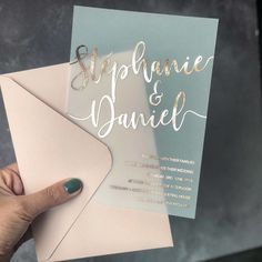 a person holding up a card with the words stephanie and danielle written on it in gold foil