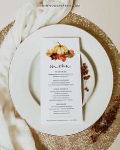 a white plate topped with a menu on top of a gold table cloth next to a napkin