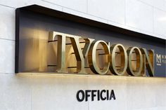 the tycoon office sign is illuminated in gold