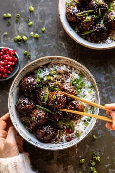 someone holding chopsticks over a bowl of meatballs and rice with garnishes