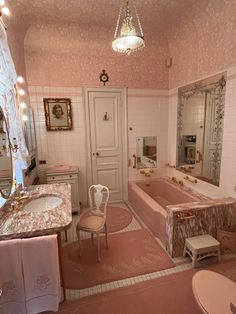 the bathroom is decorated in pink and white with gold trimmings on the walls