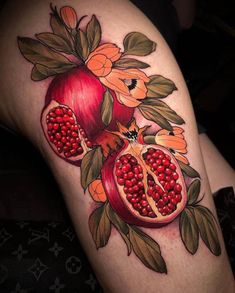 a tattoo with pomegranates and flowers on it