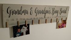 a wooden sign hanging from the side of a wall with photos pinned to clothes pins