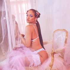 a woman sitting on top of a bed wearing a pink dress and headpieces