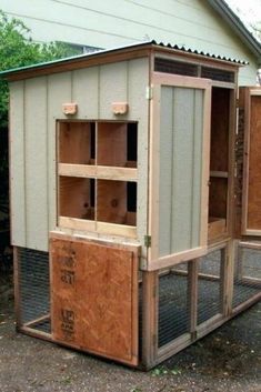 an outdoor chicken coop with the doors open