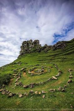 a grassy hill with rocks in the shape of a heart