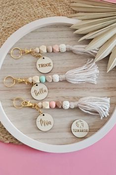 personalized tassel keychain with name and charms on it next to a palm leaf