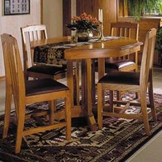 a dining room table with chairs and a rug on the floor in front of it