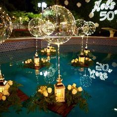 an outdoor pool decorated with candles and flowers