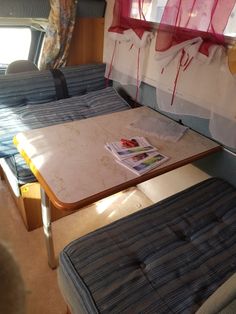 the inside of a camper with two beds and a table