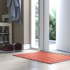 a pair of shoes sitting on top of a rug in front of a closet door