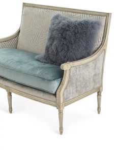 a chair with a blue pillow on top of it and a gray cushion sitting next to it