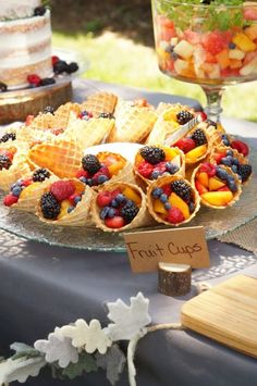 a plate with waffles and fruit on it sitting next to a glass bowl