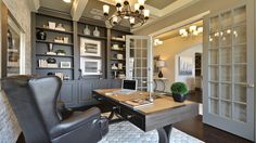 a home office with built - in shelving, desk and chair