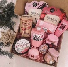 a box filled with lots of pink items next to a christmas tree and snowflakes