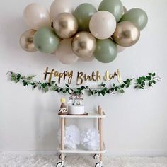 a birthday party with balloons, cake and decorations on a shelf in front of the wall