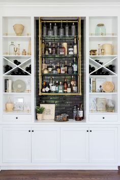 a white bookcase filled with lots of bottles