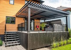 an outdoor patio area with stairs and pergolated decking on the side of a house