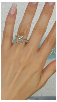 a woman's hand with a ring on it and a diamond in the middle