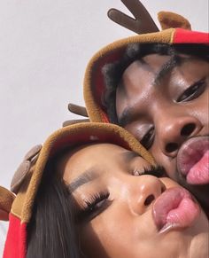 two people with fake antlers on their heads are kissing and sticking out their tongues