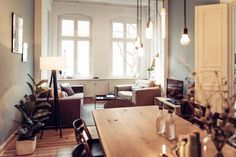 a living room filled with furniture and a wooden table in front of a large window