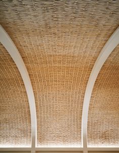 the ceiling is made of wicker and has two white columns on each side,