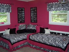 two zebra print beds in a pink room with black and white bedding on the walls