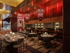 an empty restaurant with tables and chairs, lights on the ceiling and chandeliers hanging from the ceiling