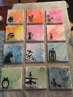 nine different colored cards with silhouettes of people and animals on them, sitting on a table