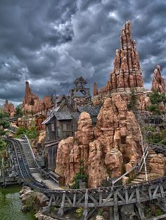 the roller coaster at disney's animal kingdom is shown under a cloudy sky with dark clouds