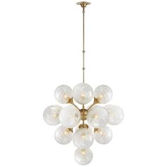 a large chandelier with white glass balls hanging from it's brass frame