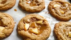 cookies with apples and caramel are on a baking sheet, ready to be eaten