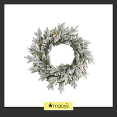 a christmas wreath with snow on it and the words macy's written in gold