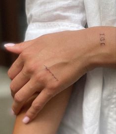 a woman's arm with a small tattoo on it