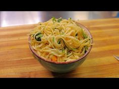 a bowl filled with noodles on top of a wooden table