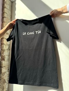 We all have that one cool tía... or you are the cool tía! Show all the Tías appreciation this Mother's Day for being great role models with this tee? *Don't forget to match your mini with our "Cool like my tía" kids tee* * Black tee/ White ink  * Unisex Fit  * Screen printed with love by JZD in Brownsville, TX * Made to order. Please allow 7-10 days. Our small but mighty team is pouring so much love in to these for all our tías. Aunt Shirt, Auntie Shirts, Aunt Shirts, Girls T Shirts, Girls Graphic Tee, Loungewear Sets, Bridal Outfits, Kid Tees, White Ink