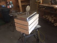 a large metal box sitting on top of a dolly in a garage next to some shelves