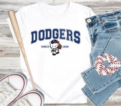 One Bella Canvas Unisex T-Shirt with blue Dodger design, color of your choice. Trendy Hello Kitty Print T-shirt For Streetwear, Casual Hello Kitty T-shirt For Streetwear, Dodgers Shirts, Custom Shirt, Design Color, Womens Clothing Tops, Custom Shirts, Bella Canvas, Unisex T Shirt