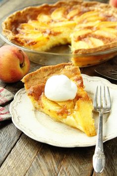 a piece of pie on a plate with a fork next to it and an apple in the background