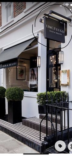 an image of a store front with potted plants on the steps and in front