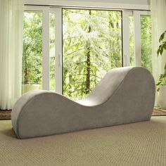 a couch sitting on top of a carpet covered floor in front of a large window