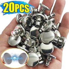 a hand holding a bunch of metal buttons